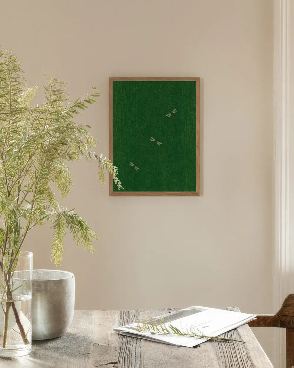 Poster in een interieur: Drie kleine lichte libellen op een diep bosgroene achtergrond met fijne houtdrukachtige structuur