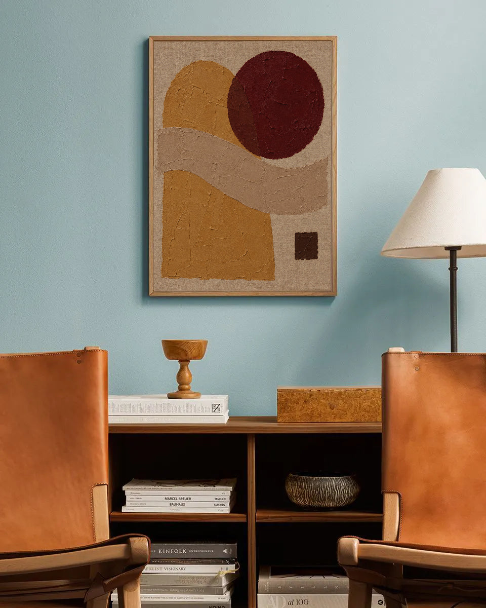 Poster in een interieur: Abstracte geschilderde vormen in oker en zand met een bordeauxrode cirkel en klein donker vierkant
