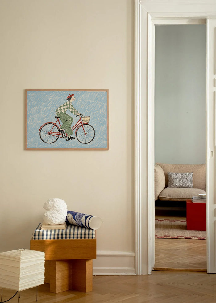 Poster in een interieur: Illustratie van een fietser met groen geruite trui op een rode fiets tegen een lichtblauwe achtergrond